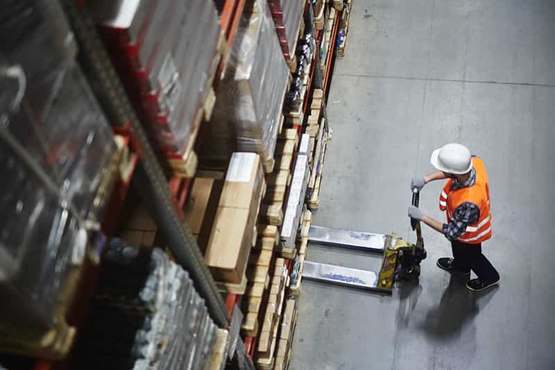 overhead view of an Ottawa industrial real estate property where a logistics worker loads a pallet onto a pallet jack